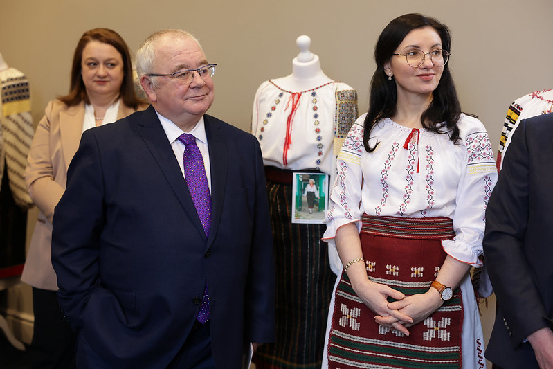 Ceann Comhairle posing with a woman wearing traditional Moldovan dress as part of the launch of an exhibition
