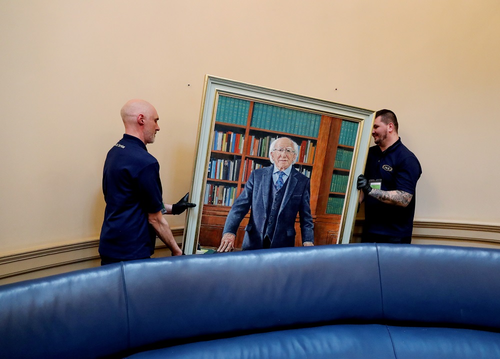 OPW staff hanging the official portrait of President Michael D. Higgins